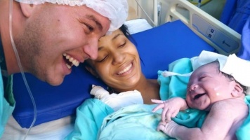 Az újszülött baba sugárzó mosollyal üdvözli apját, amikor felismeri a hangját