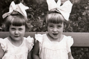 >
      két kislány masnival a hajukban
      néznek a kamerába