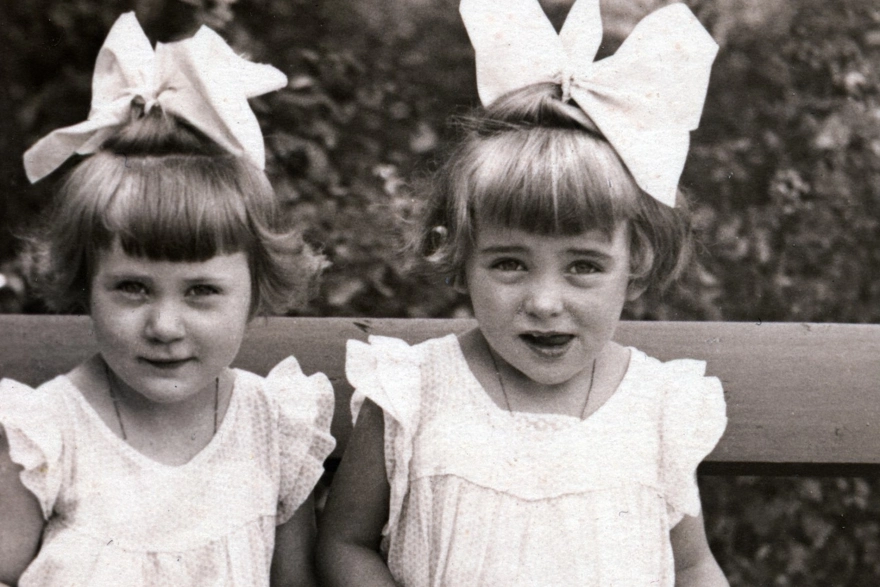 két kislány masnival a hajukban néznek a kamerába